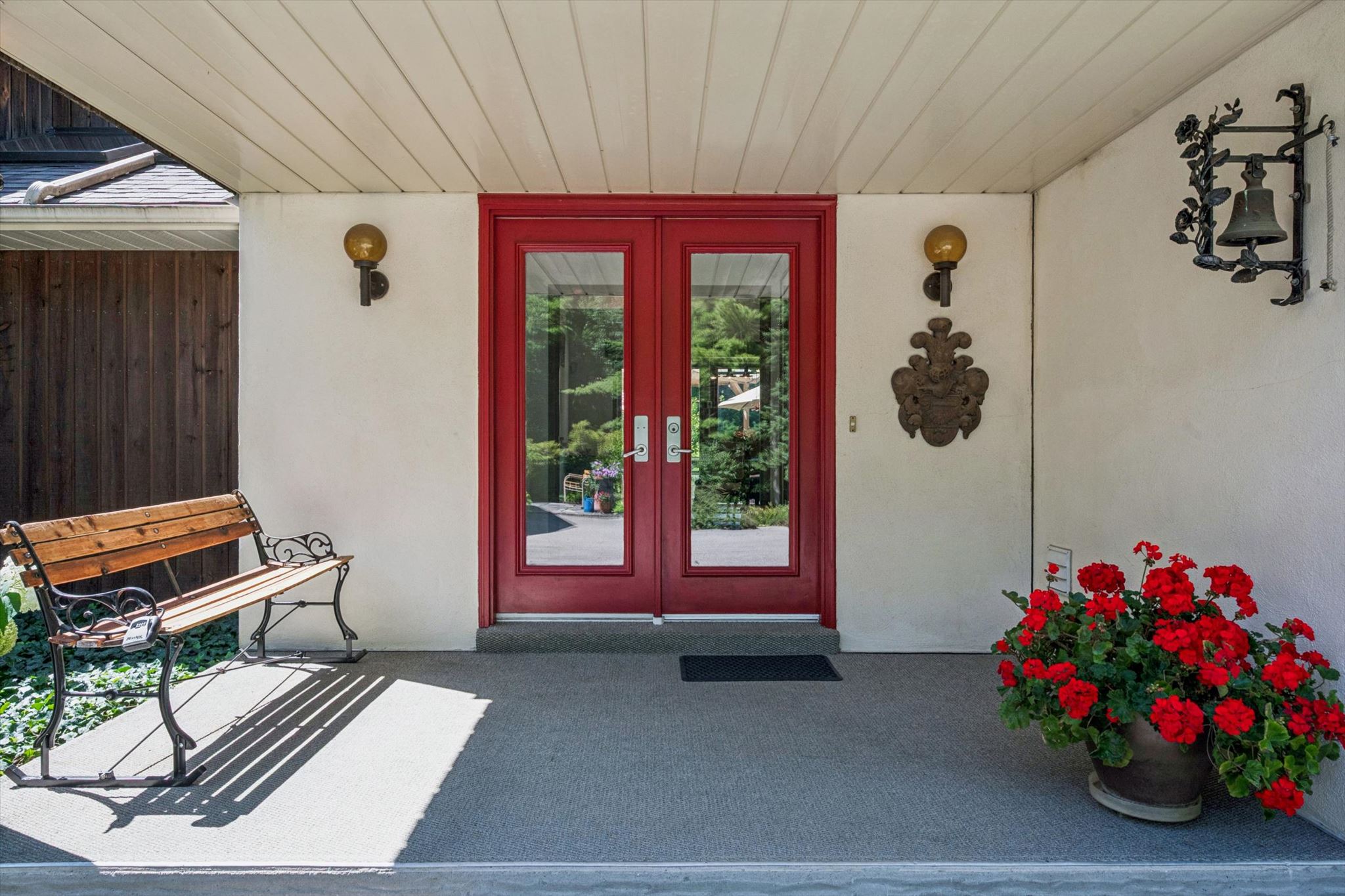 Red double doors under the sheltered entry