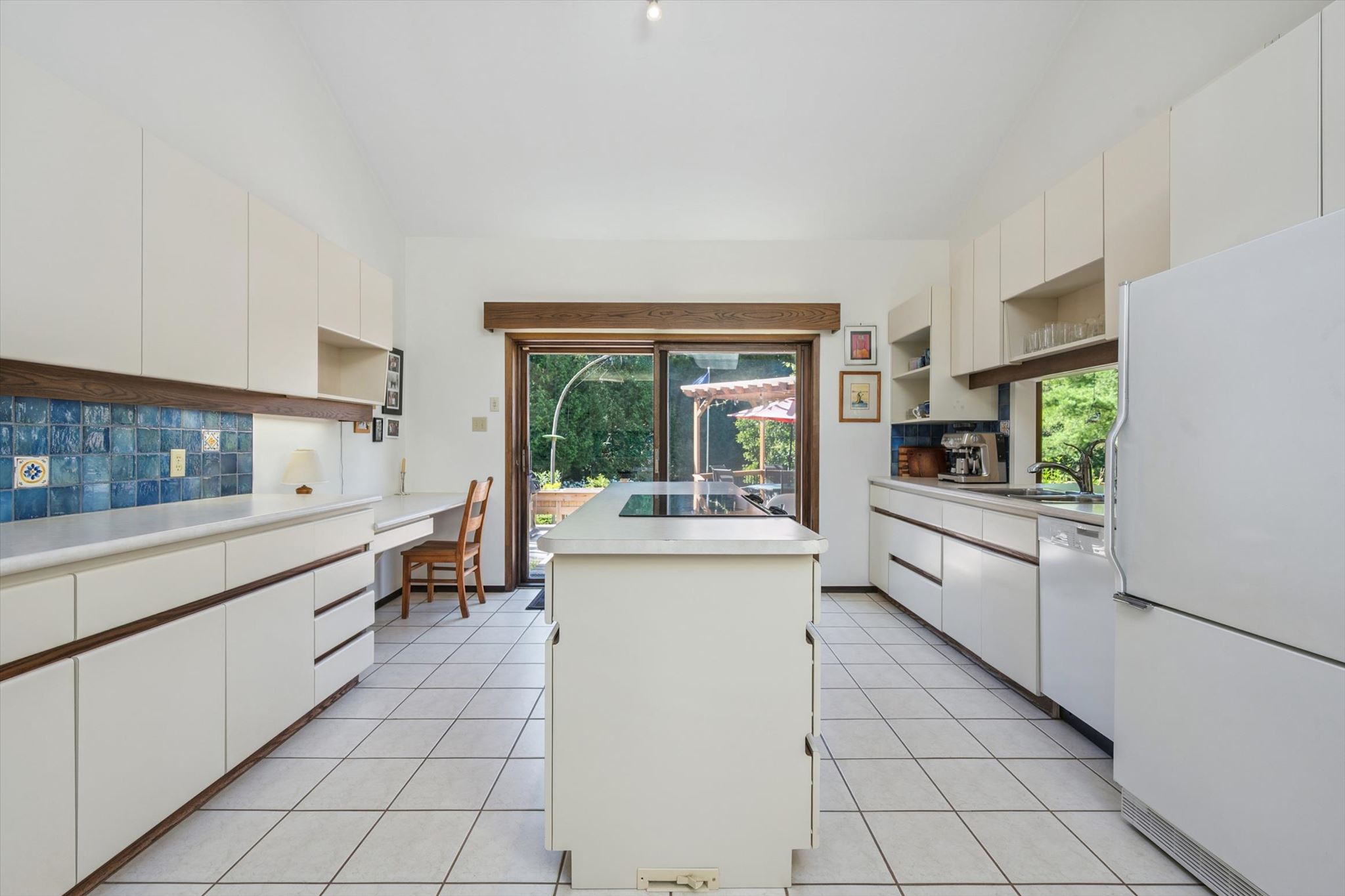 Galley kitchen with island cooktop and deck access