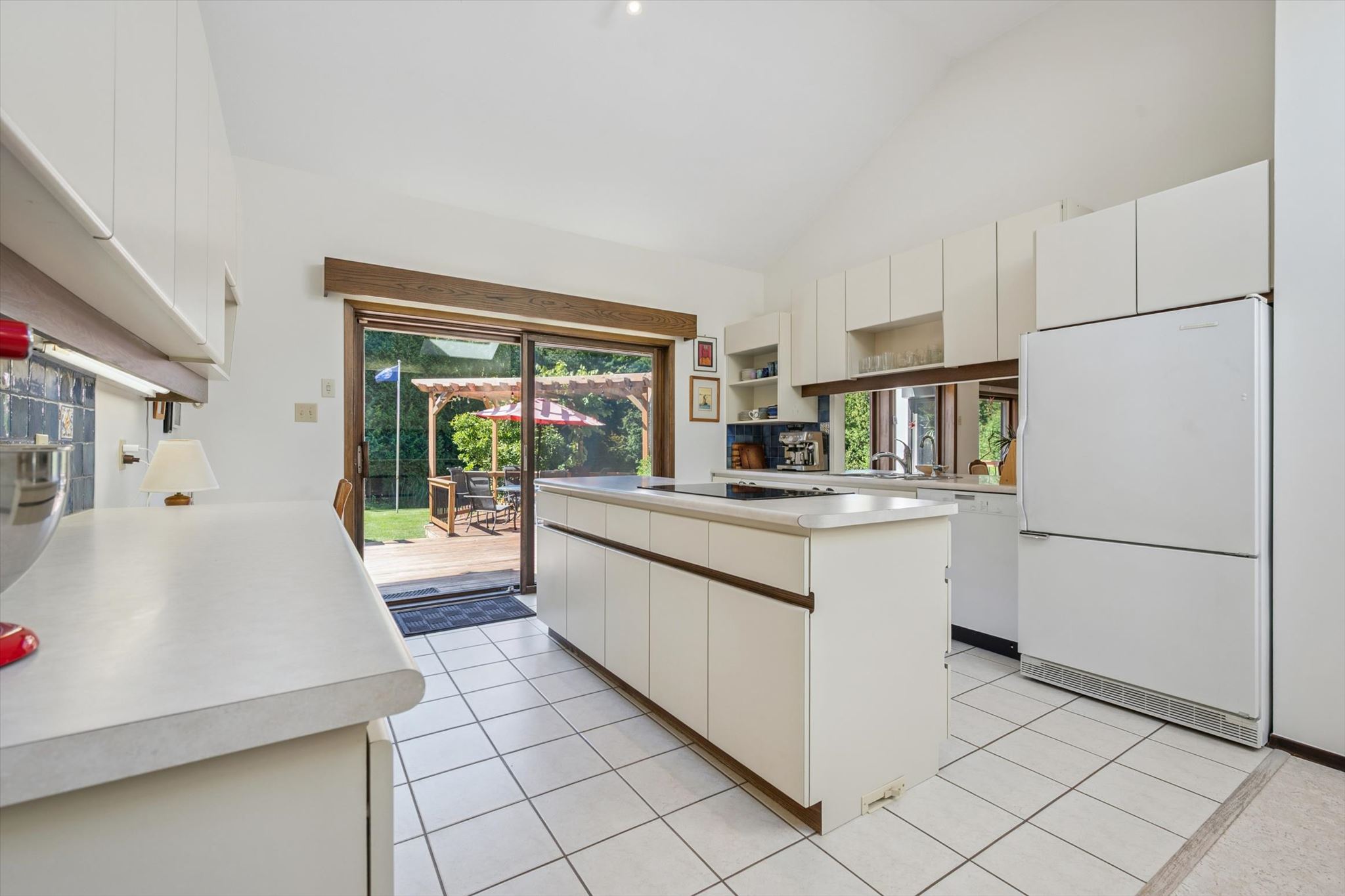 Kitchen opening to the deck and pergola