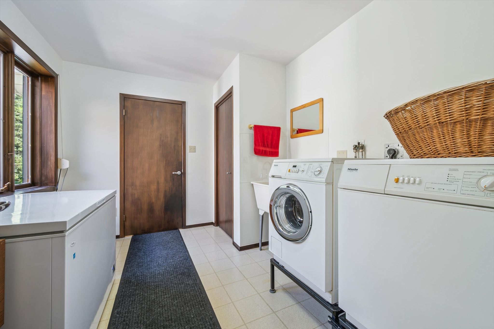 Main floor laundry, with sink and freezer