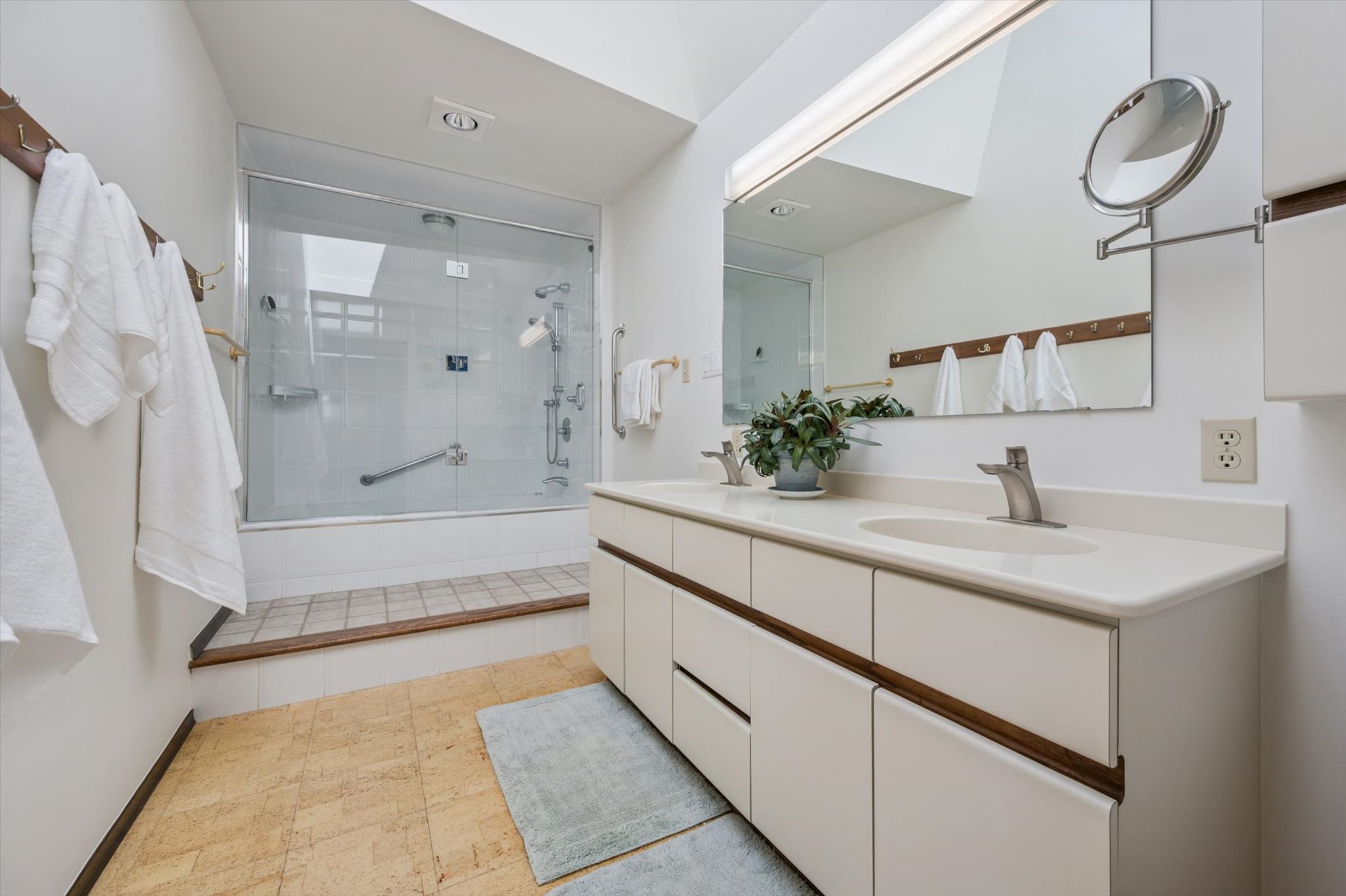 Ensuite bath with double vanity beneath a skylight