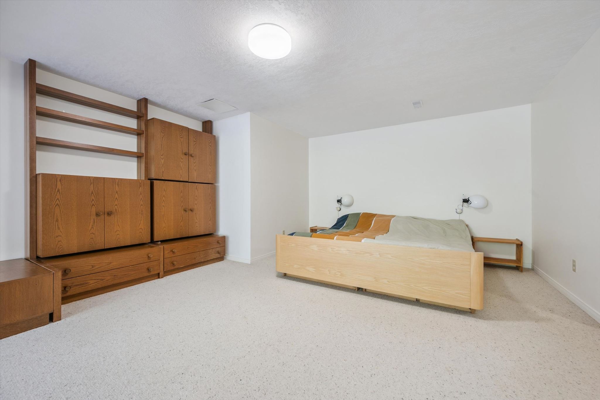 Lower level bedroom with built-in oak wall unit