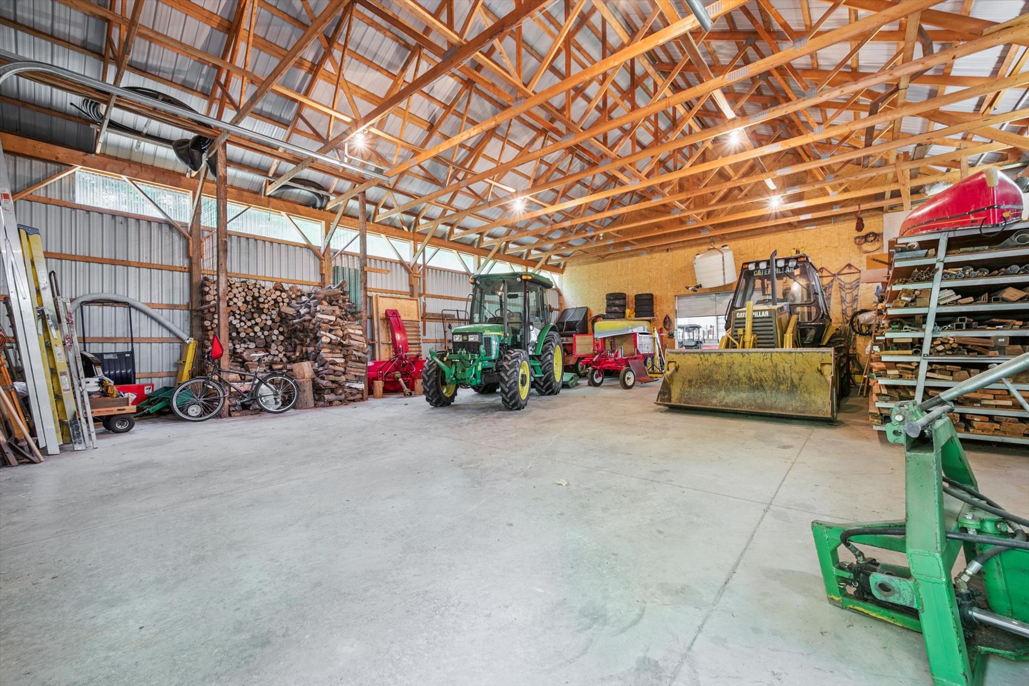 Inside the equipment barn — tractor, loader and a winter of firewood